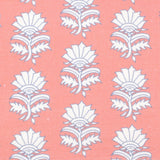 Detail of fabric in a repeating thistle print in white and blue on a pink field.