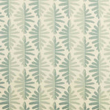 Detail of fabric in a fern leaf print in shades of green on a cream field.