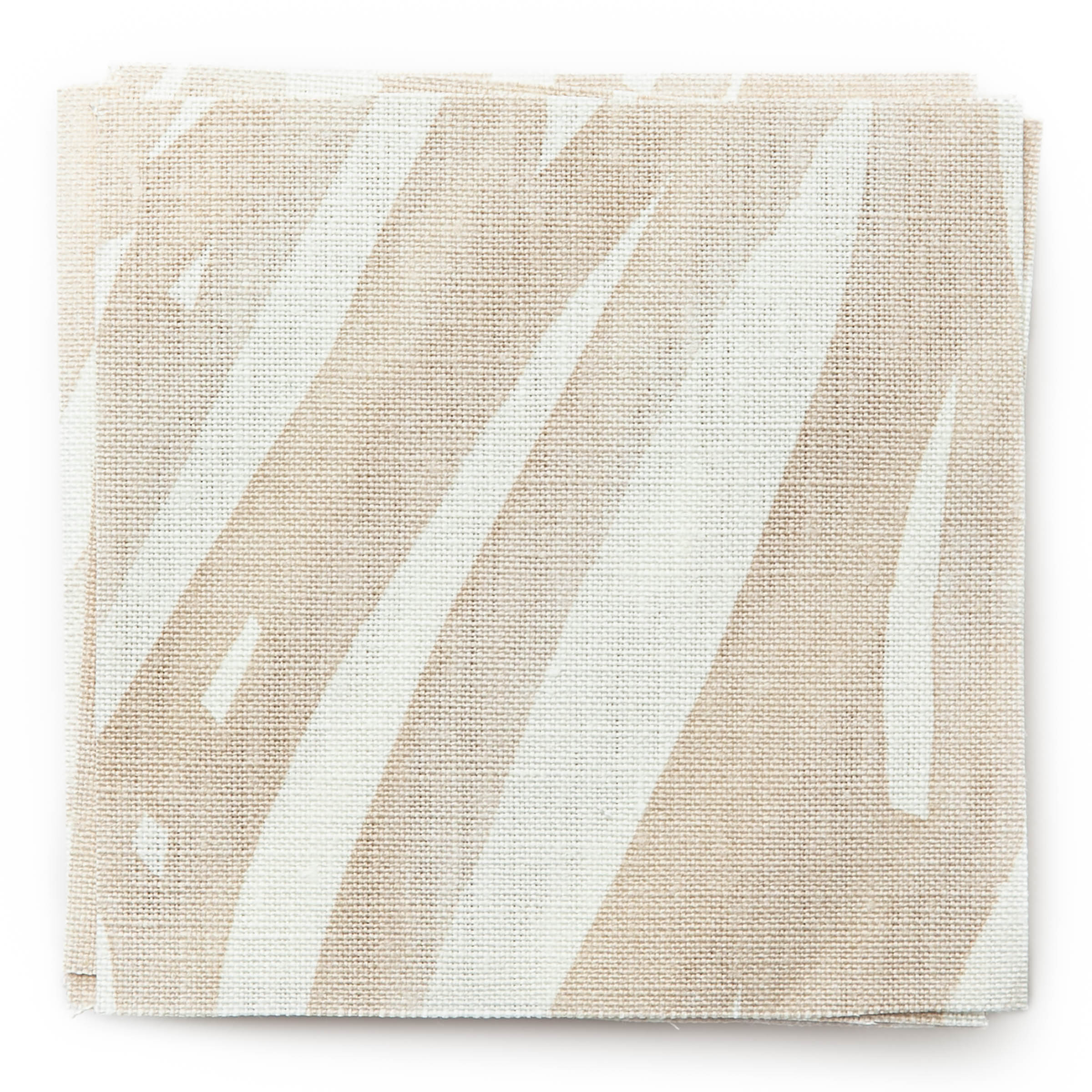 A stack of fabric swatches in an abstract leaf pattern in white on a cream watercolor field.