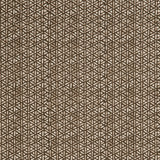 Detail of a linen fabric in a detailed geometric pattern in white on a dark brown field.