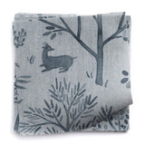 A stack of fabric swatches in a playful animal and tree print in navy on a blue-gray field.