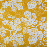 Detail of fabric in a playful botanical print in yellow and white on a bright yellow field.