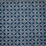 Detail of fabric in a repeating geometric print in cream on a navy field.