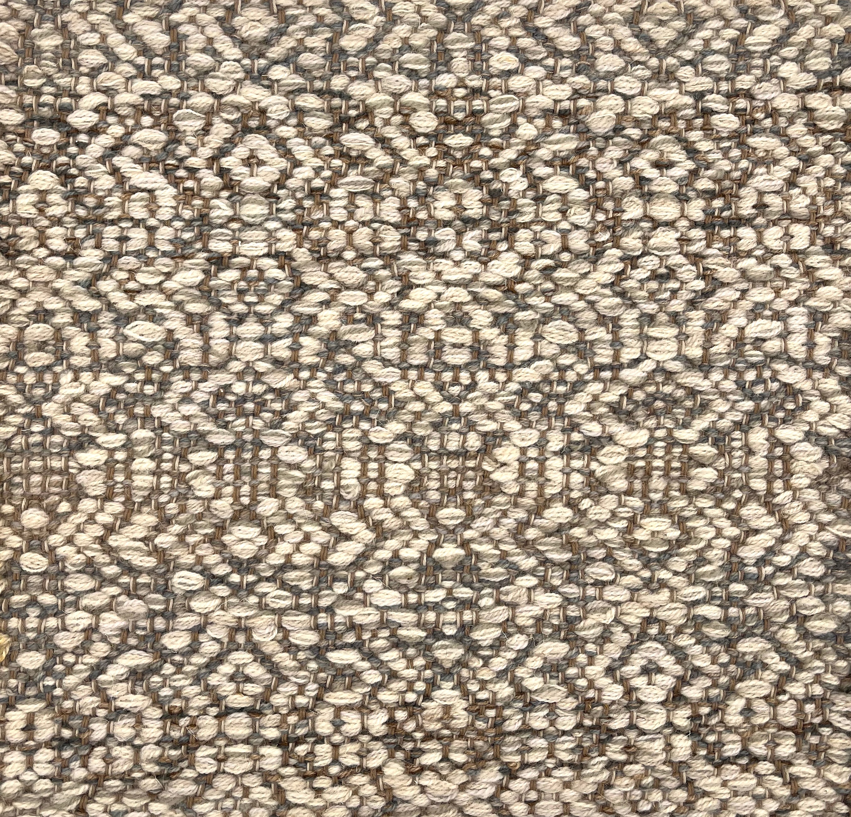 Handwoven rug detail in a contemporary design in grey and cream