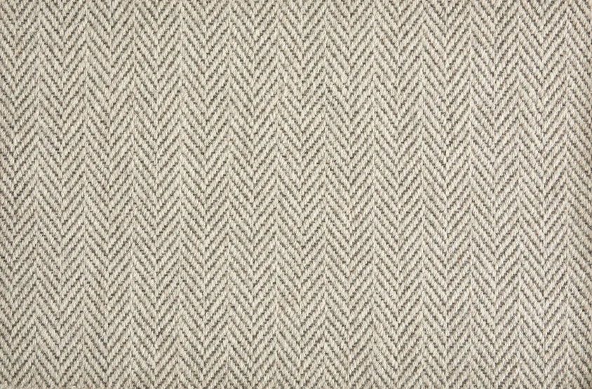 Broadloom carpet in a herringbone pattern in ivory and taupe.