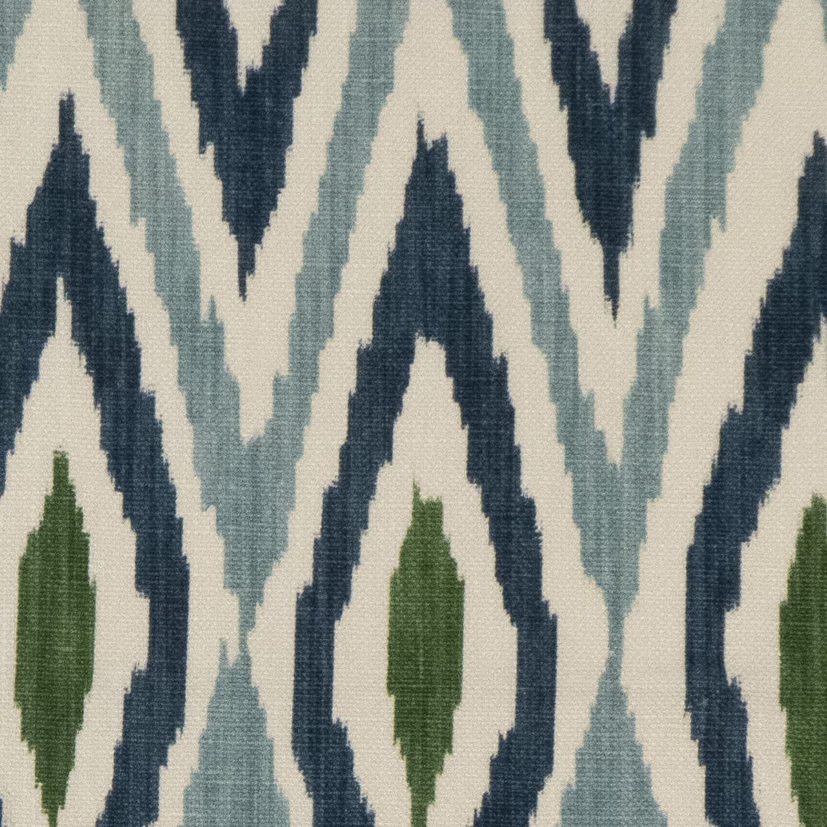 Detail of fabric in a geometric ikat print in shades of blue, navy and green on a tan field.