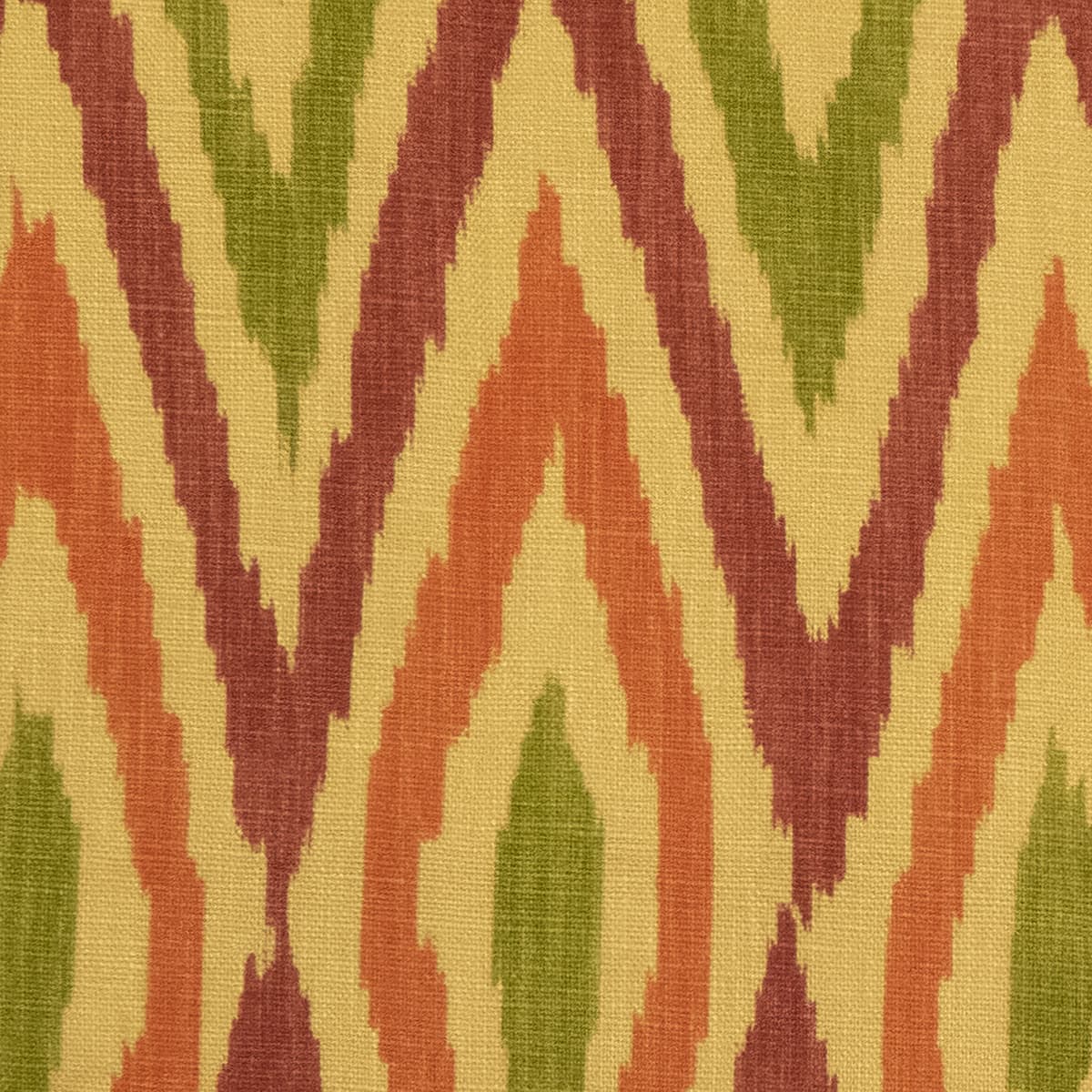 Detail of fabric in a geometric ikat print in shades of red, orange and green on a yellow field.