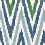 Detail of wallpaper in a geometric ikat print in shades of blue, navy and green on a white field.