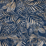 Detail of fabric in a dense leaf print in mottled cream and tan on a navy field.