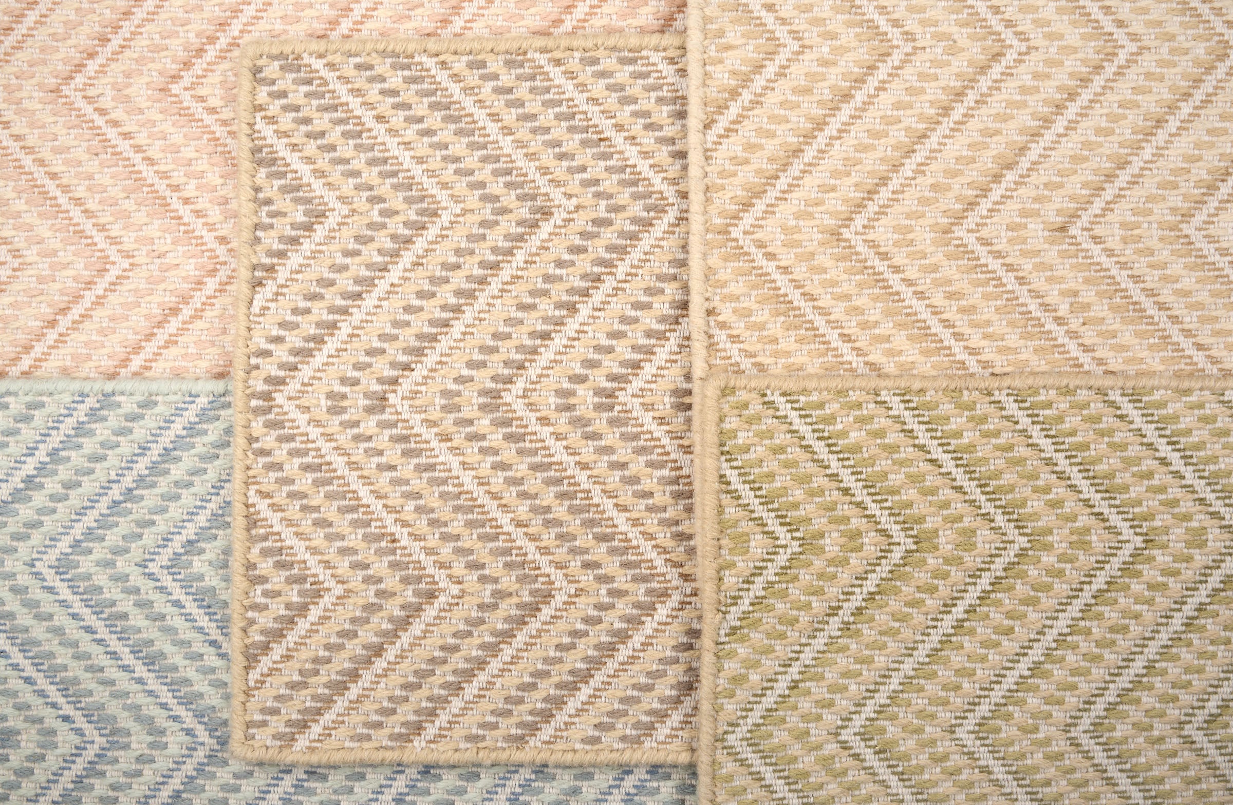 Stack of broadloom carpets with zig zag pattern in various colors. 