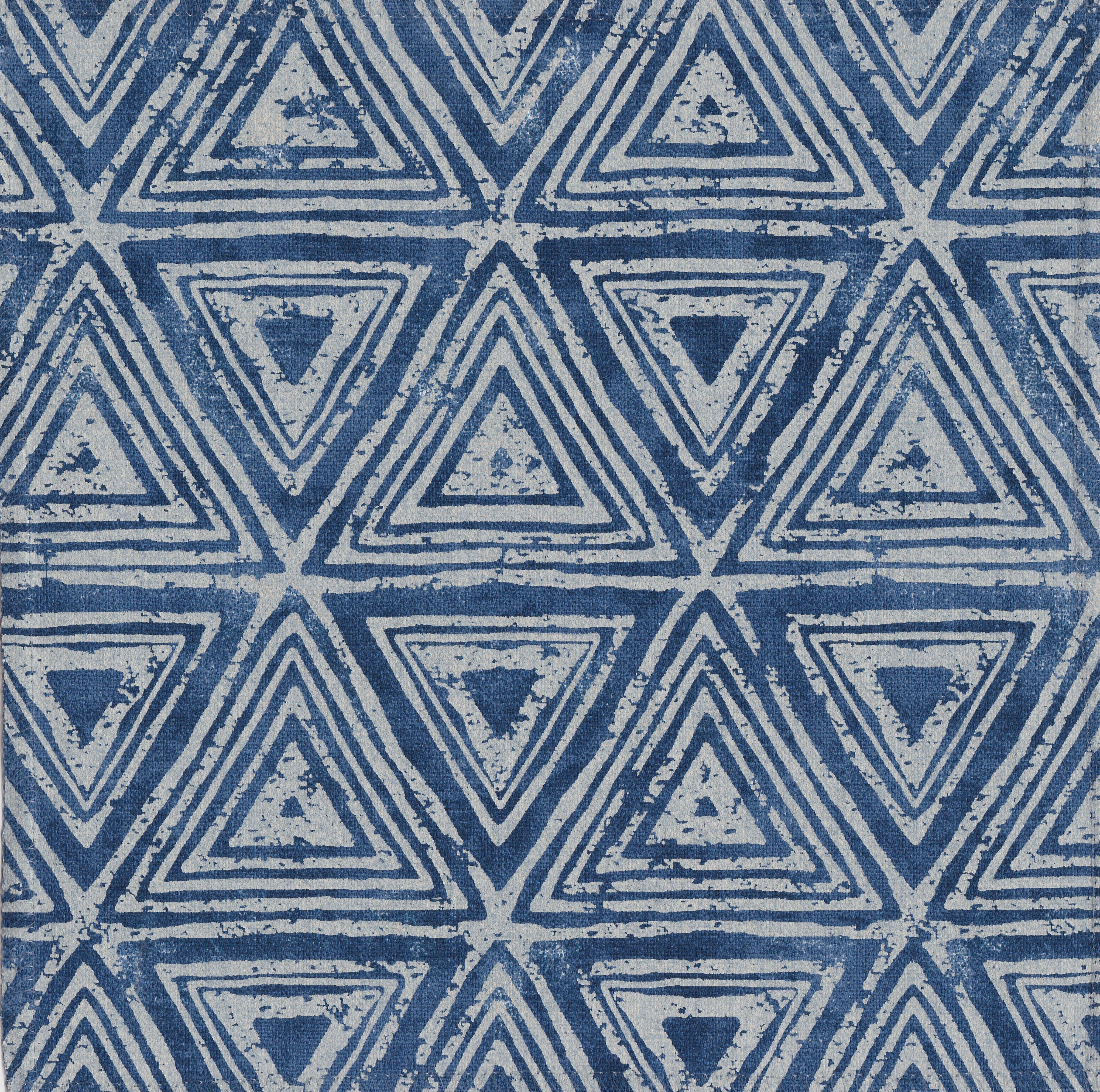 Detail of fabric in a triangular grid print in shades of blue and navy.