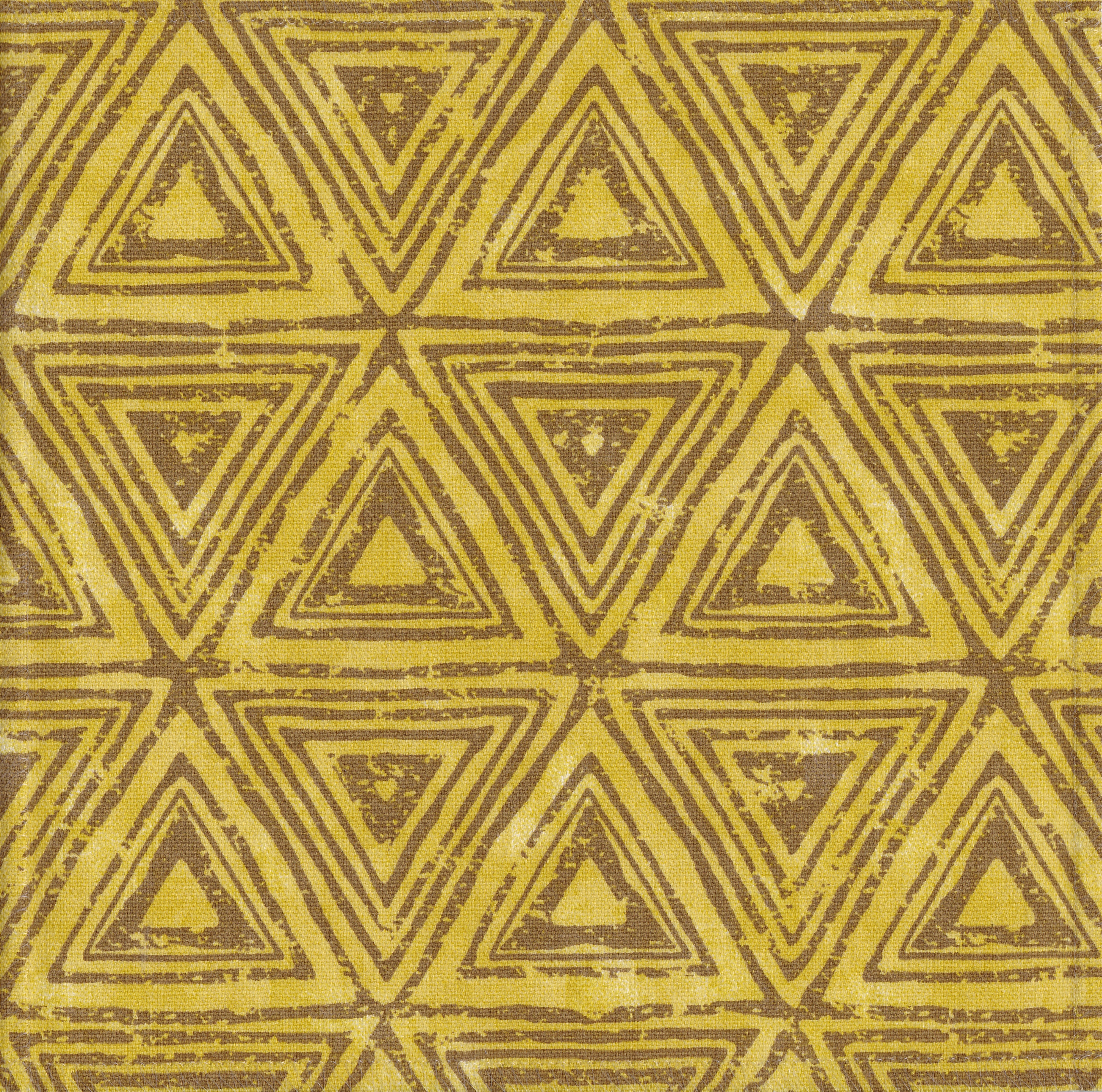 Detail of fabric in a triangular grid print in shades of brown and yellow.