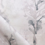 Detail of draped fabric yardage in an abstract botanical print in shades of light gray and pink on a cream field.