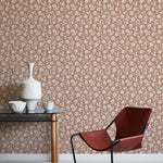 Modern chair and table against a floral wallpapered wall