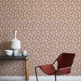 Modern chair and table against a floral wallpapered wall