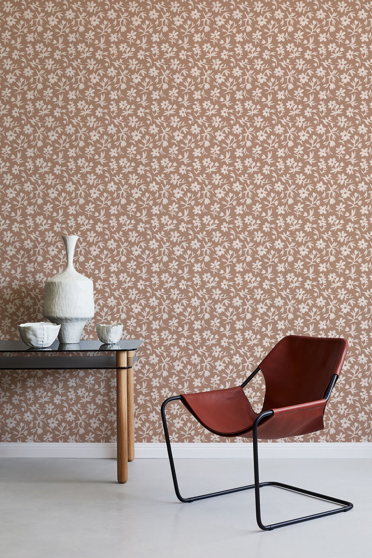 Modern chair and table against a floral wallpapered wall