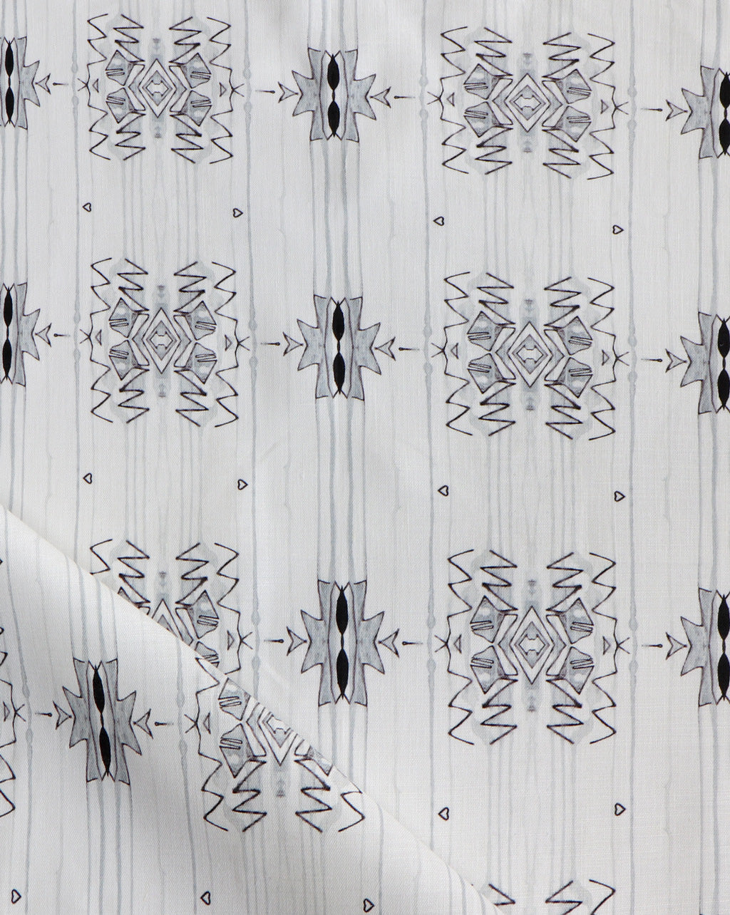 Detail of draped fabric yardage in a minimalist ikat pattern in shades of gray on a white field.