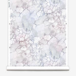 Partially unrolled wallpaper yardage in an abstract textural print in shades of white, purple and gray.