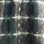 Draped fabric yardage in a cloudy ink blot print in shades of gray and blue on a light gray field.