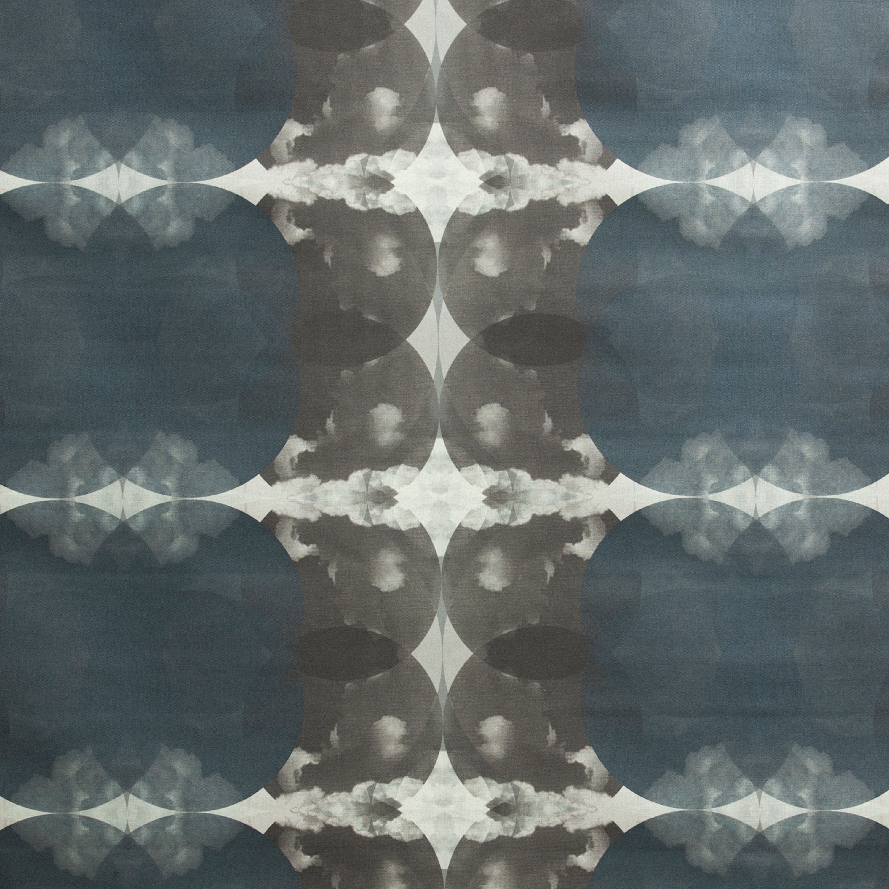 Detail of fabric in a cloudy ink blot print in shades of gray and blue on a light gray field.