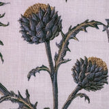 Detail of fabric in a repeating artichoke print in shades of purple, brown and green on a light purple field.