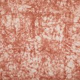 Detail of velvet fabric in an organic crumpled texture in coral on a cream field.
