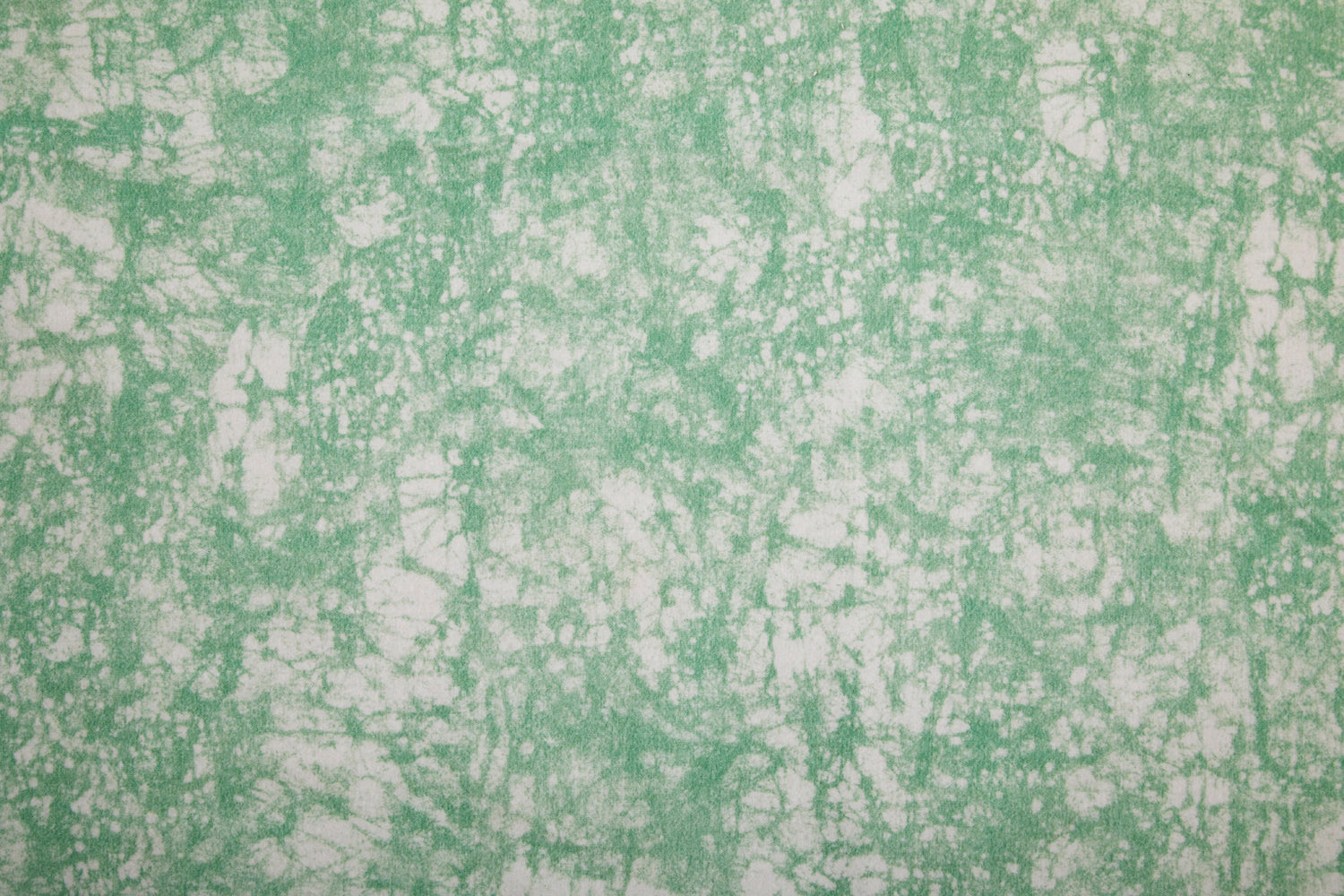 Detail of velvet fabric in an organic crumpled texture in light green on a cream field.