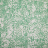 Detail of velvet fabric in an organic crumpled texture in light green on a cream field.