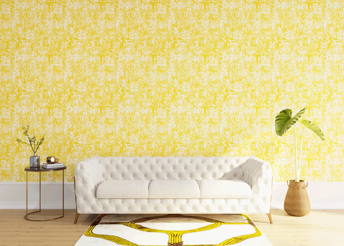 Styled living room tableau with a wall papered in an organic textural print in yellow on a white field.