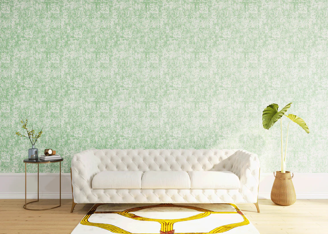 Styled living room tableau with a wall papered in an organic textural print in light green on a white field.