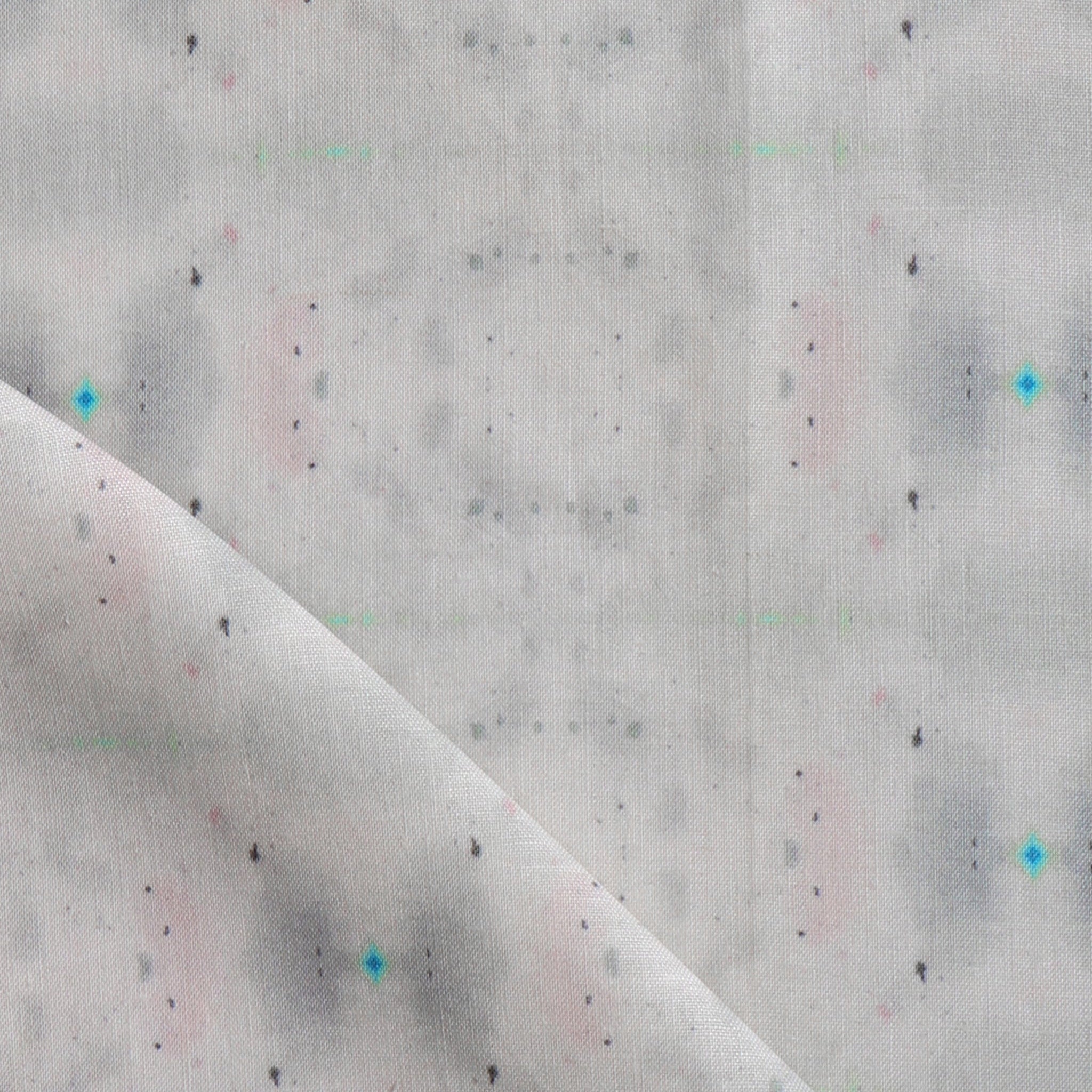 Detail of draped fabric yardage in a repeating ink blot print in shades of gray with turquoise and pink accents.