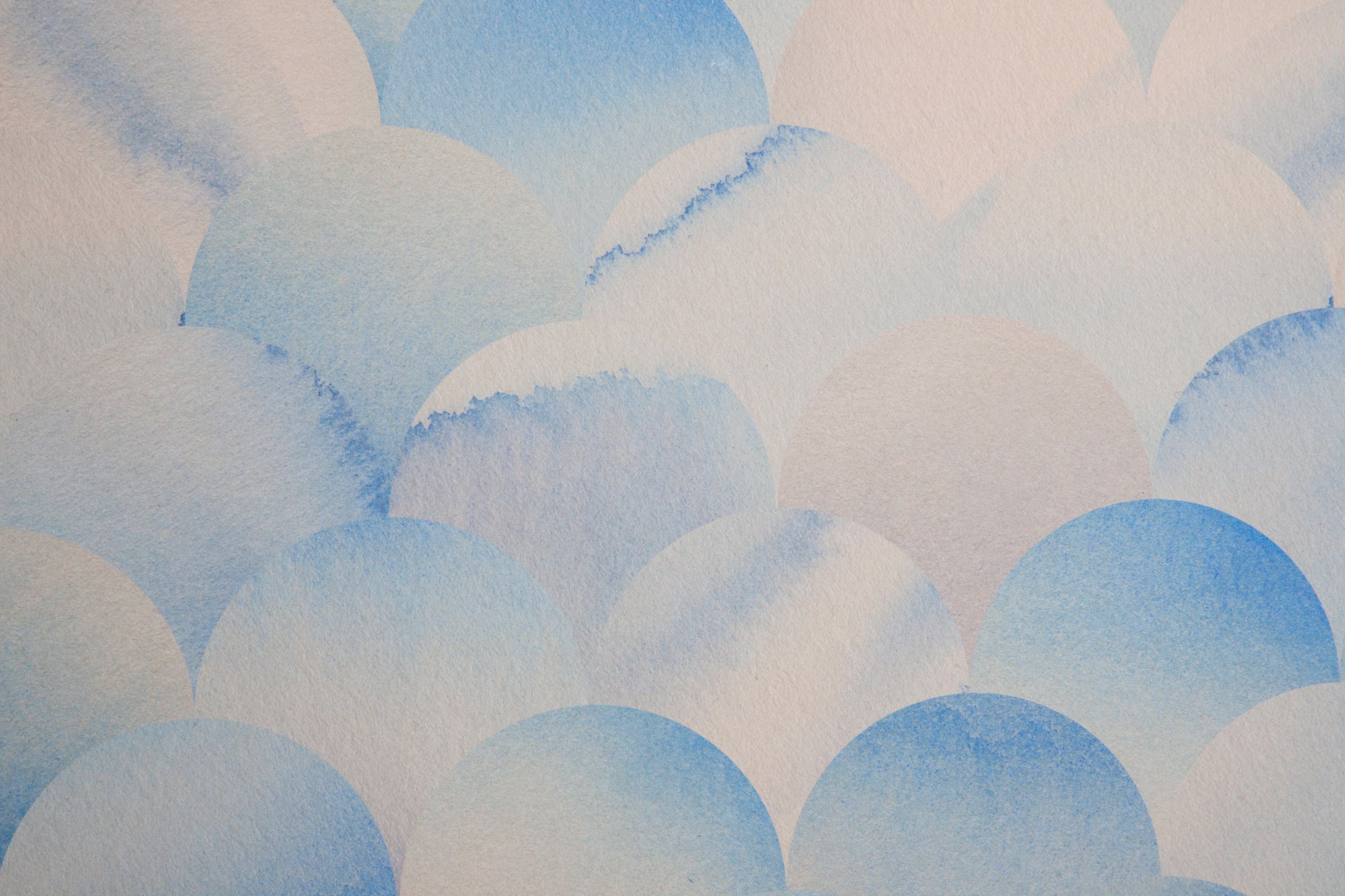 Detail of wallpaper in a repeating scalloped print in shades of blue and tan.