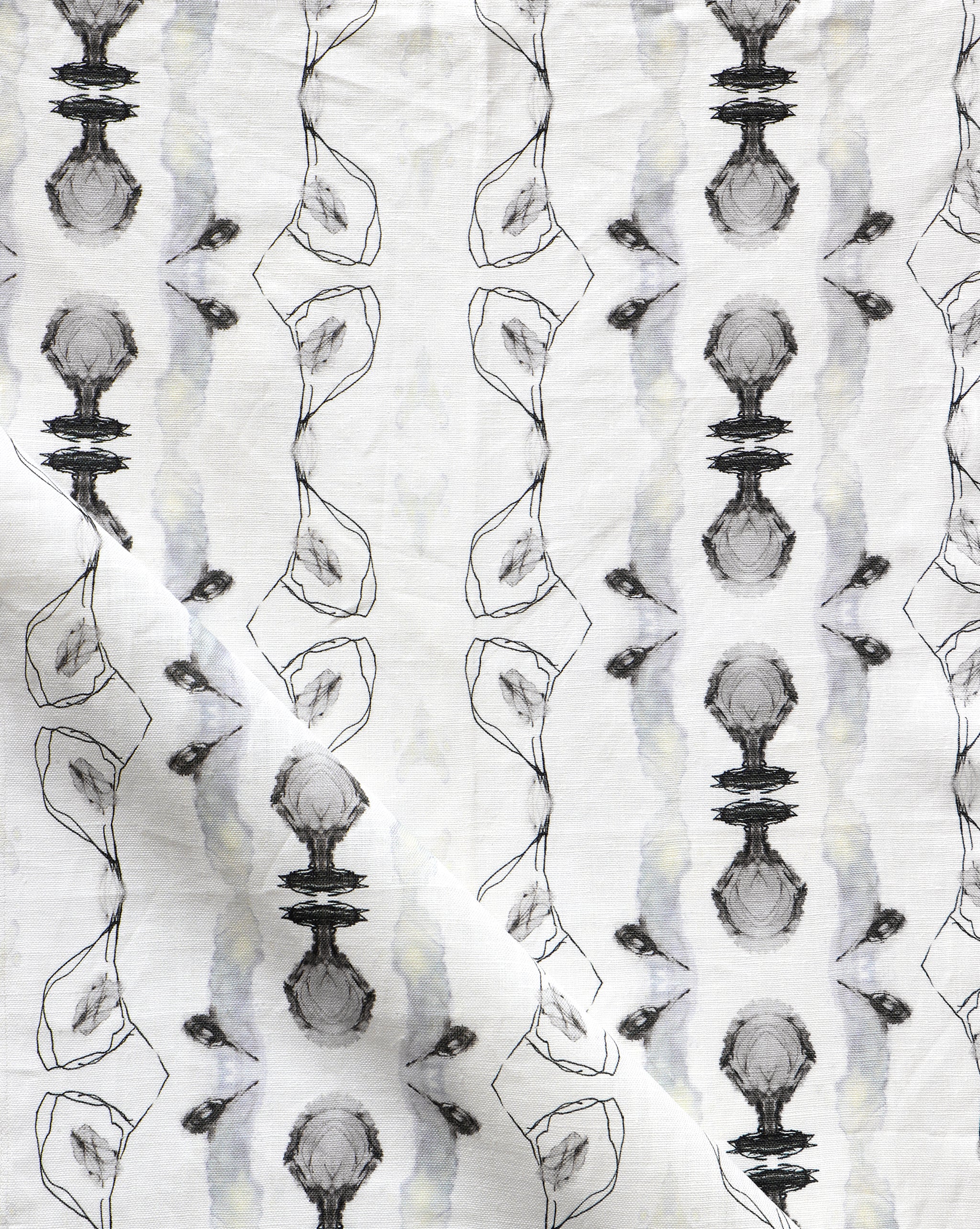 Detail of draped fabric yardage in a watercolor ikat stripe print in shades of gray and black on a white field.