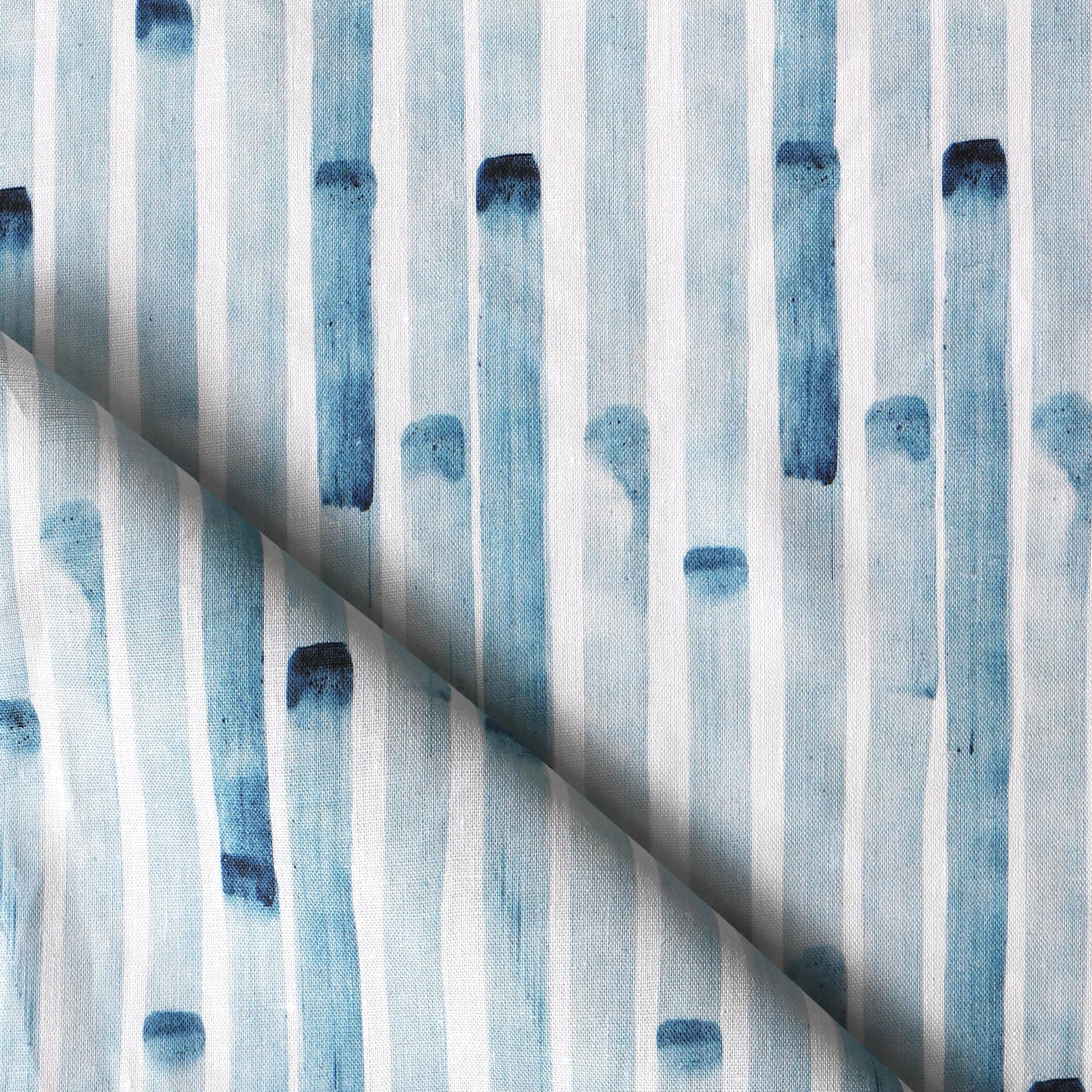 Detail of draped fabric in a painterly stripe print in blue on a white field.