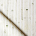 Detail of draped fabric in a painterly stripe print in tan on a white field.