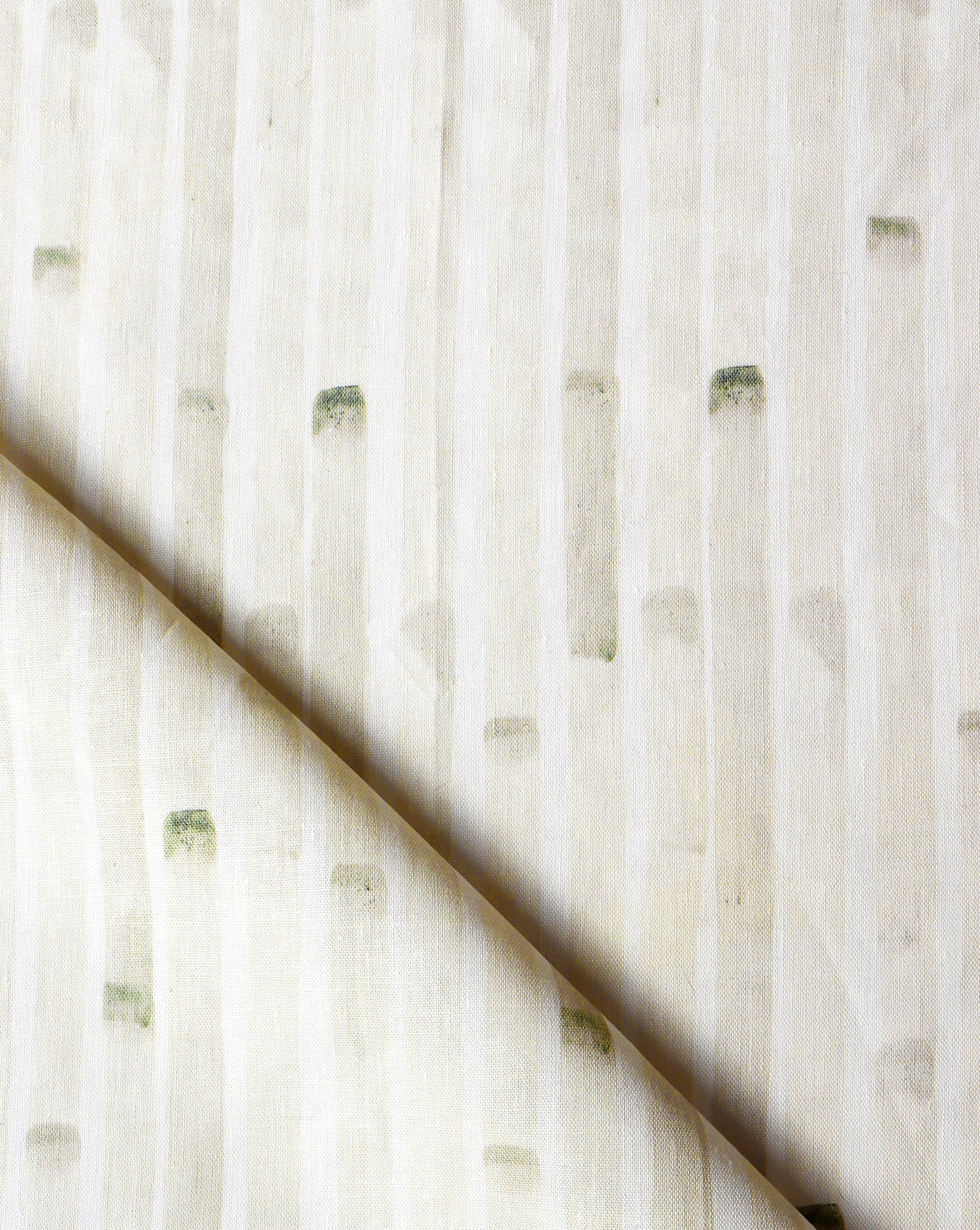 Detail of draped fabric in a painterly stripe print in tan on a white field.