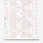 Partially unrolled wallpaper yardage in an abstract dyed grid print in mottled white and pink.