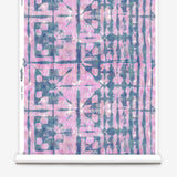 Partially unrolled wallpaper yardage in an abstract dyed grid print in mottled pink and navy.