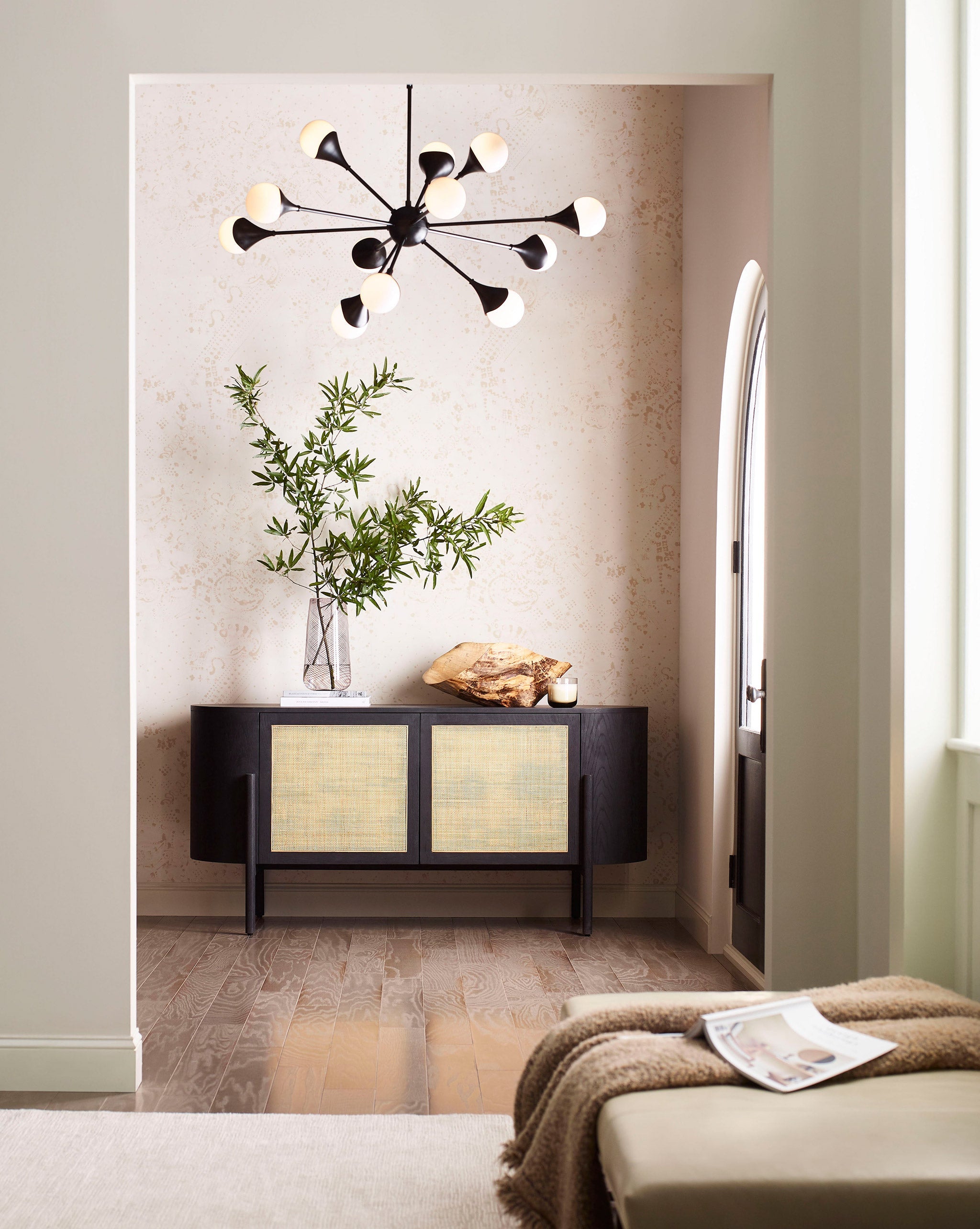 A modernist living space with an accent wall papered in a painterly bandana print in beige and cream.