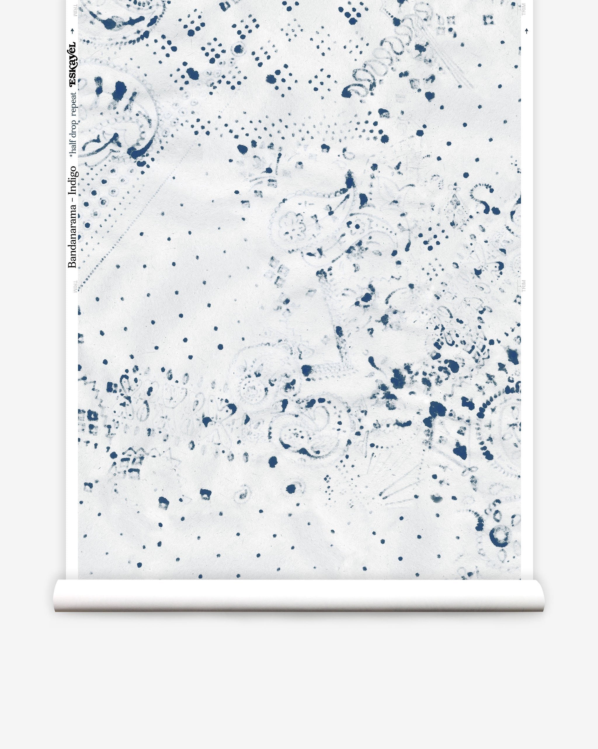 Partially unrolled wallpaper yardage in a painterly bandana print in navy on a white field.