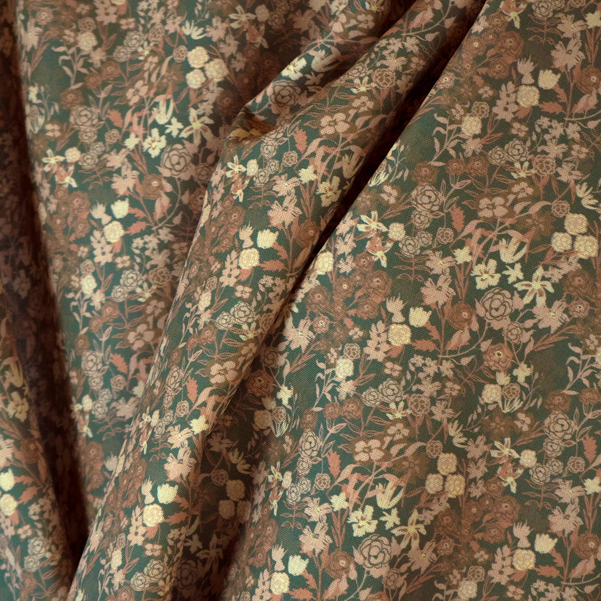 Draped fabric yardage in a dense small-scale floral print in shades of brown and tan on a green field.