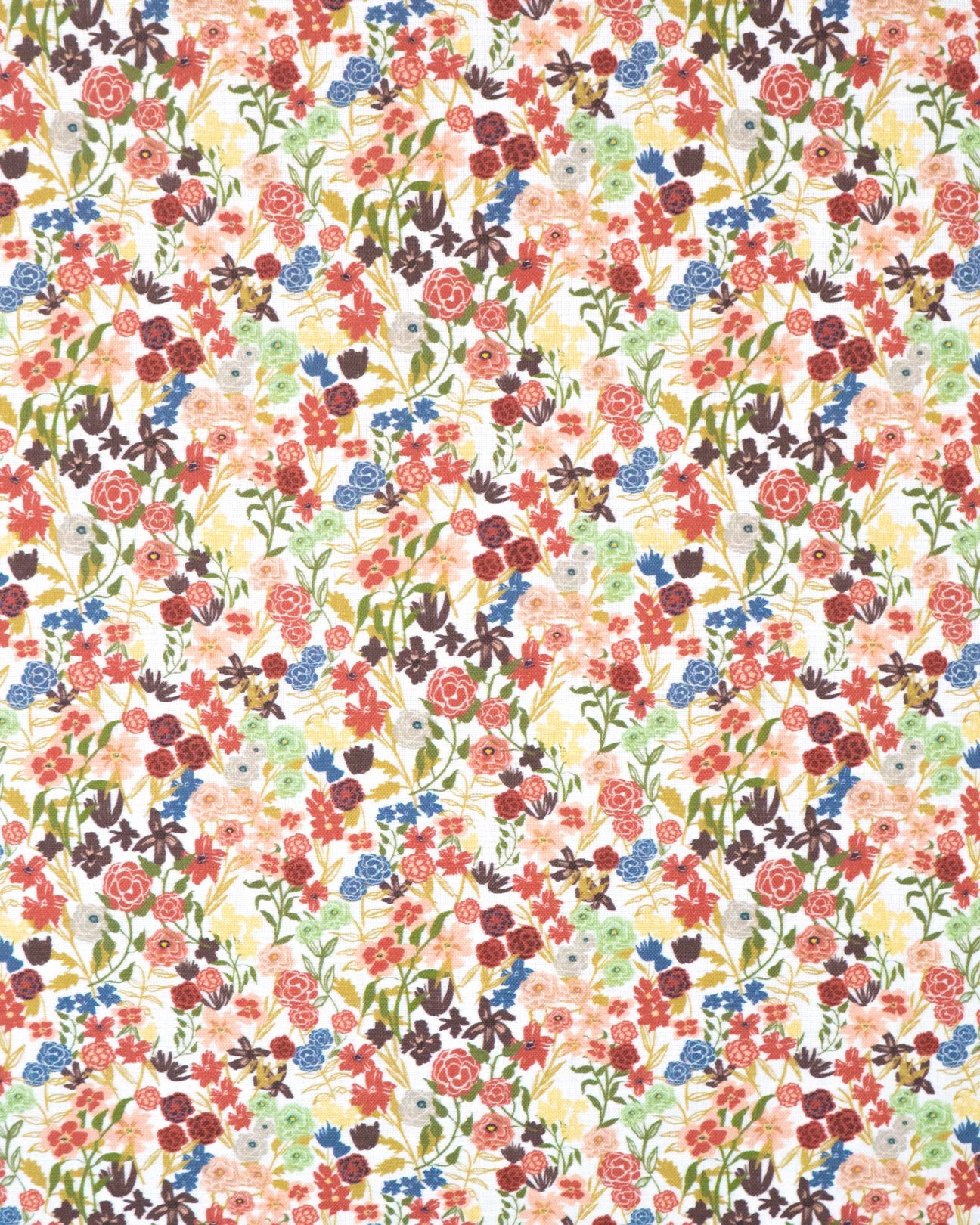 Detail of fabric in a dense small-scale floral print in shades of coral, red, green and blue on a white field.