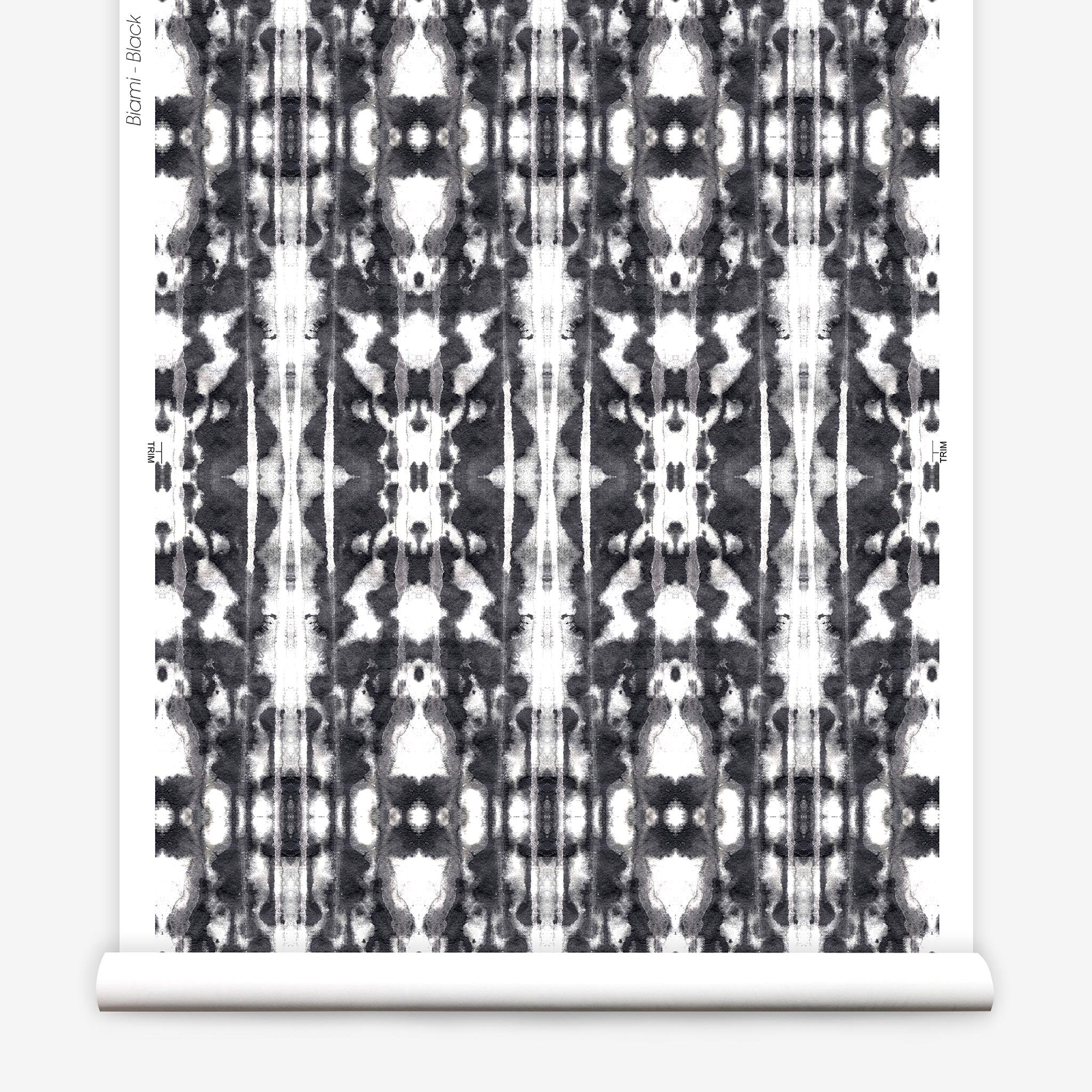 Partially unrolled wallpaper yardage in a painterly ikat print in black on a white field.