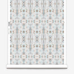 Partially unrolled wallpaper yardage in a painterly ikat print in turquoise, gray and tan.