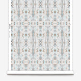 Partially unrolled wallpaper yardage in a painterly ikat print in turquoise, gray and tan.