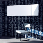 A modernist living tableau with walls papered in a painterly ikat print in blue and white.