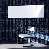 A modernist living tableau with walls papered in a painterly ikat print in blue and white.