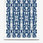 Partially unrolled wallpaper yardage in a painterly ikat print in blue and white.