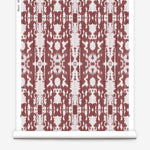 Partially unrolled wallpaper yardage in a painterly ikat print in rust and white.