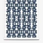 Partially unrolled wallpaper yardage in a painterly ikat print in navy and white.